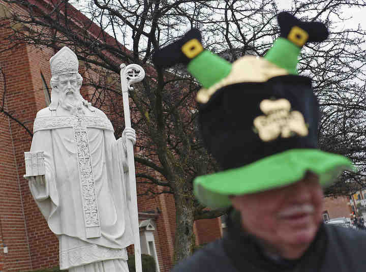 A statue of St. Patrick eyes Mark Sullivan of Akron at St. Patricks Church before the parade in Columbus.    (Eric Albrecht / The Columbus Dispatch)